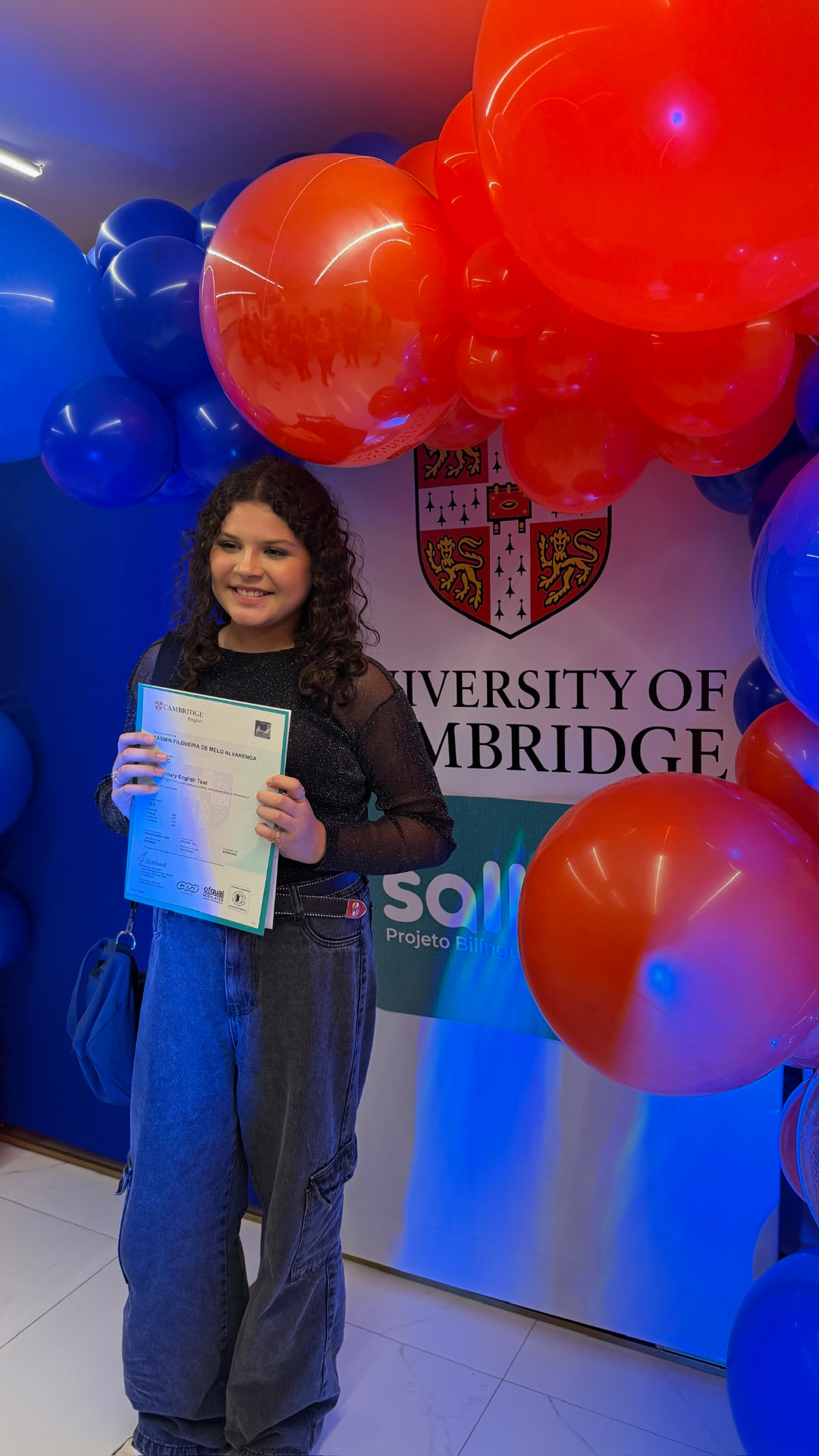 Aluna Cambridge com painel University of Cambridge