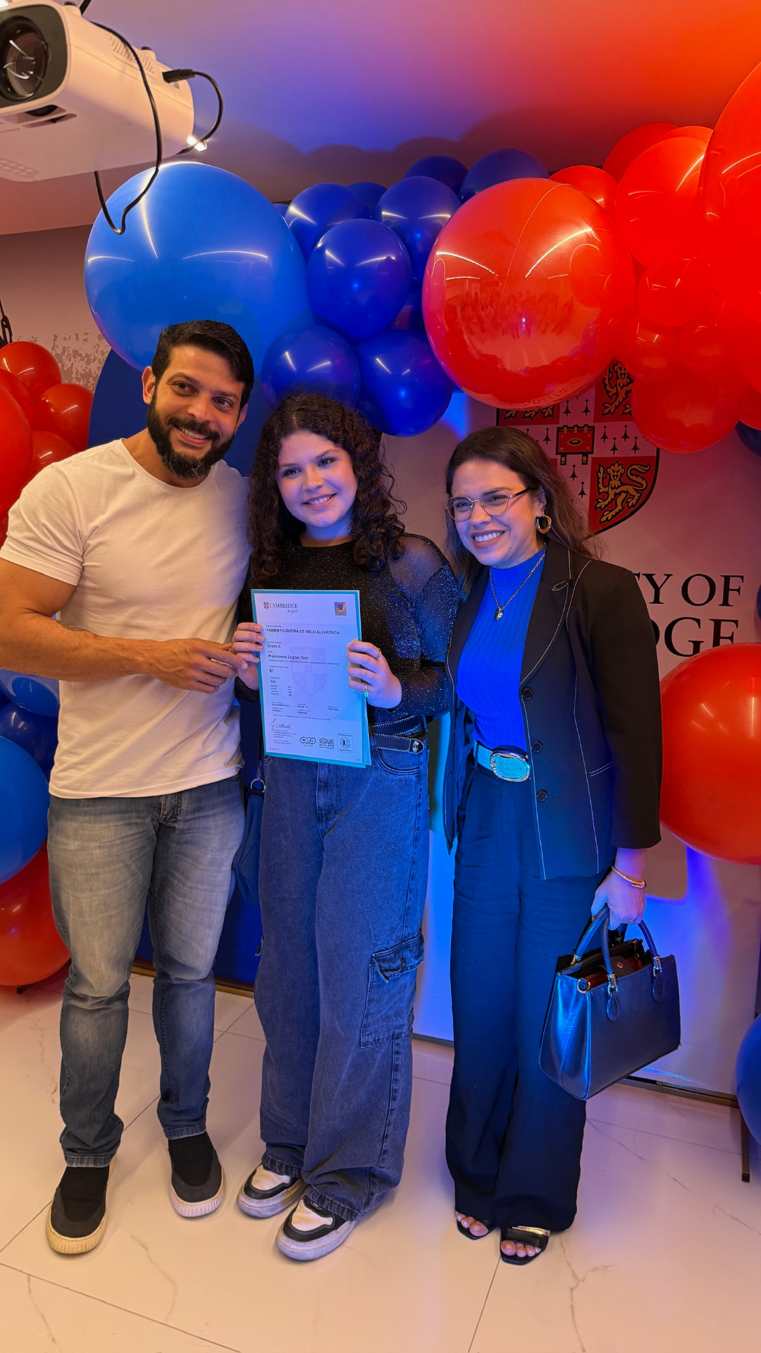 Aluna e pais celebrando certificação Cambridge