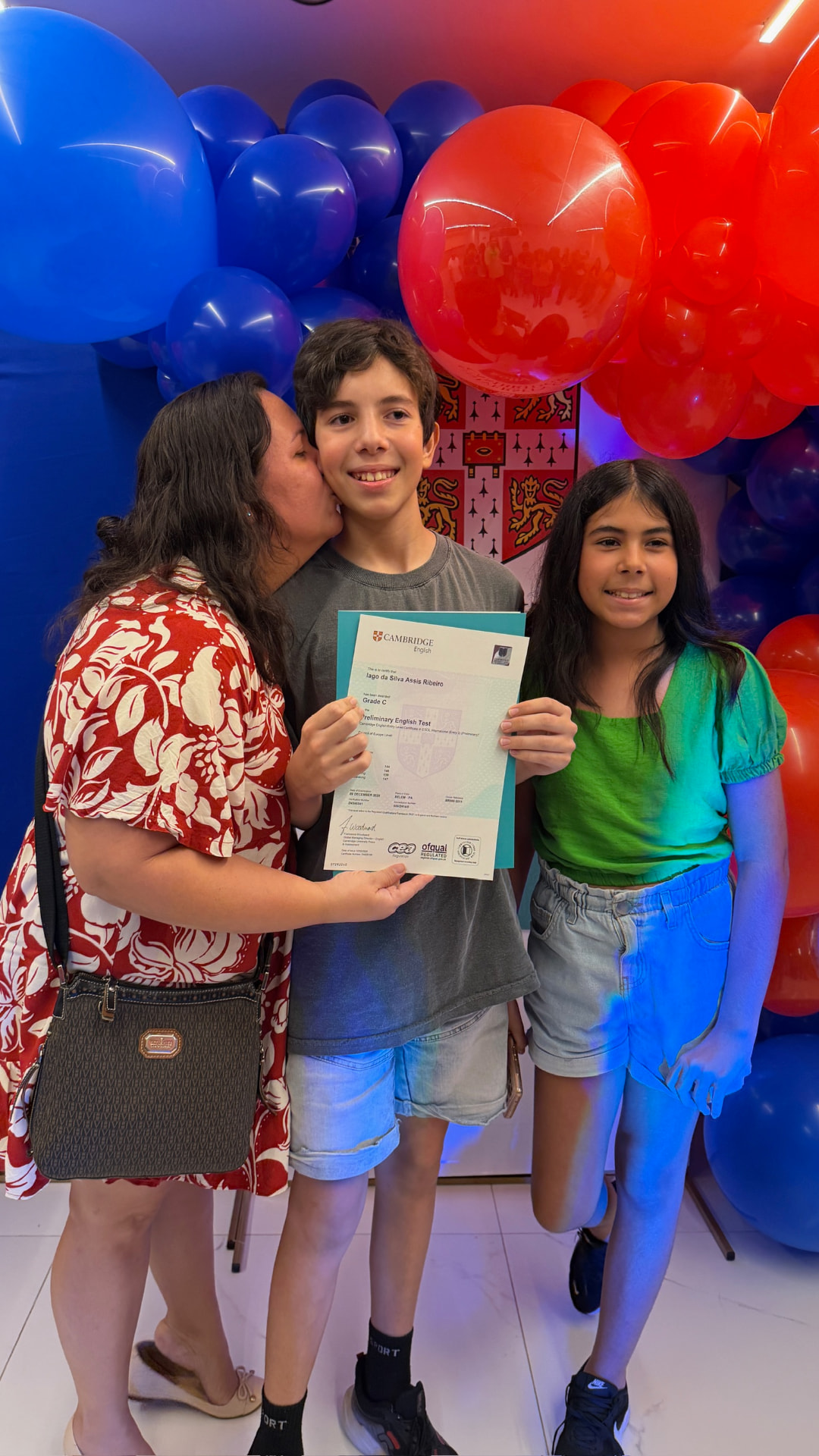 Aluno recebendo carinho da família com certificado